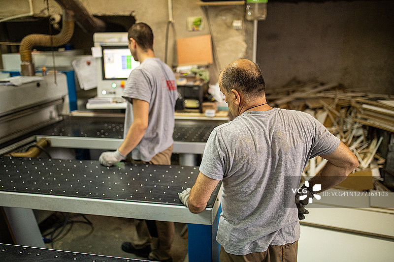 木工公司的手工工人使用数控机床切割胶合板图片素材