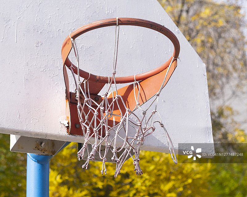 一个旧的篮球自制戒指挂在电线杆上。童年记忆的情感。在一个蓝色的夏季天空背景上复制空间图片素材