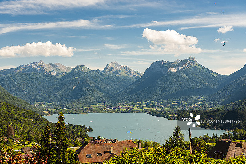 法国，萨伏伊，安纳西，滑翔伞飞过湖面的全景图片素材