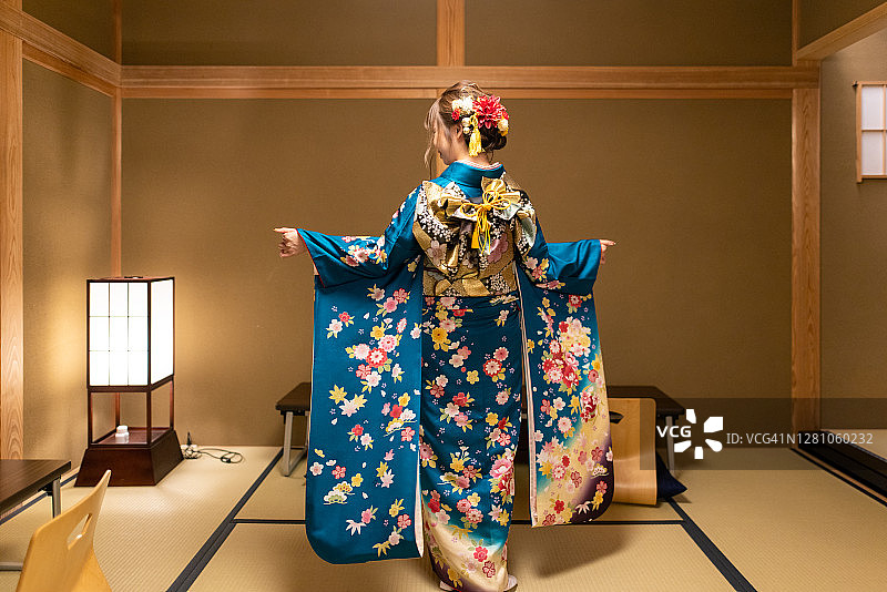 年轻女子在“日式旅馆”的榻榻米房间里穿着“Furisode”和服跳舞图片素材