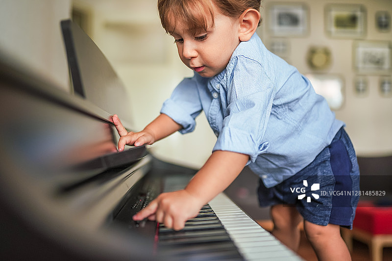小男孩对学钢琴很好奇图片素材