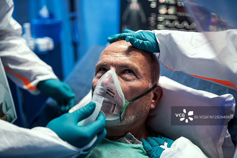 医生为住院的covid-19老年患者发放通风口罩，冠状病毒概念。图片素材