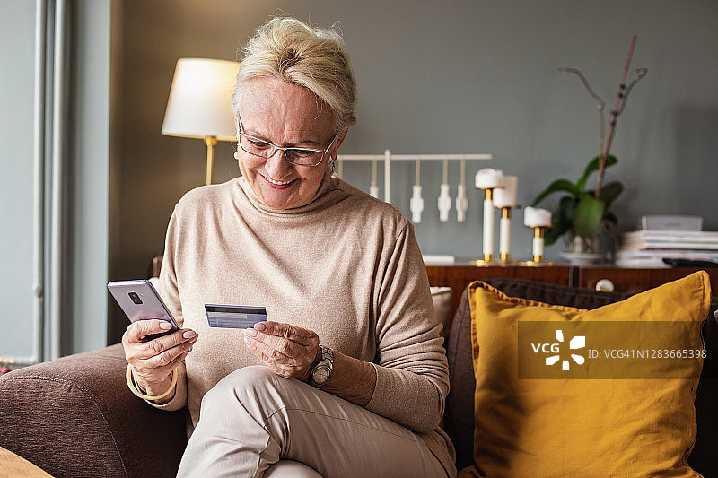 老女人通过手机在家网上购物图片素材
