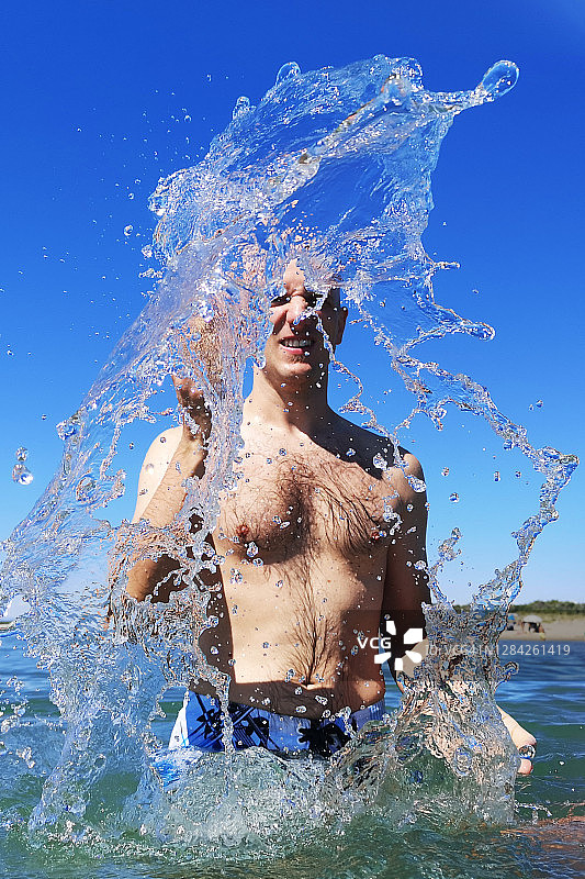 意大利，男子站在海中溅水图片素材