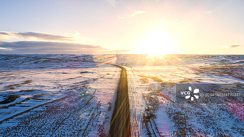 道路的景色是美丽的，覆盖着冰雪岛周围的冰岛。使用无人机拍摄的美丽鸟瞰图。图片素材