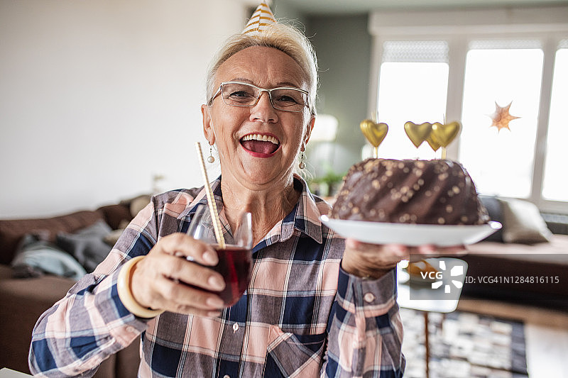 一位老妇人拿着生日蛋糕的肖像图片素材