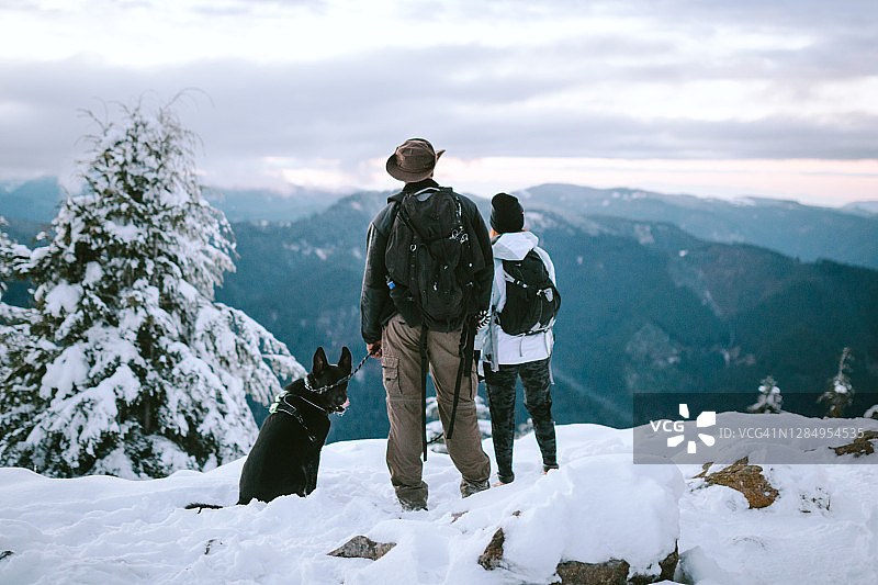 徒步旅行者和狗在雪覆盖的太平洋西北部图片素材