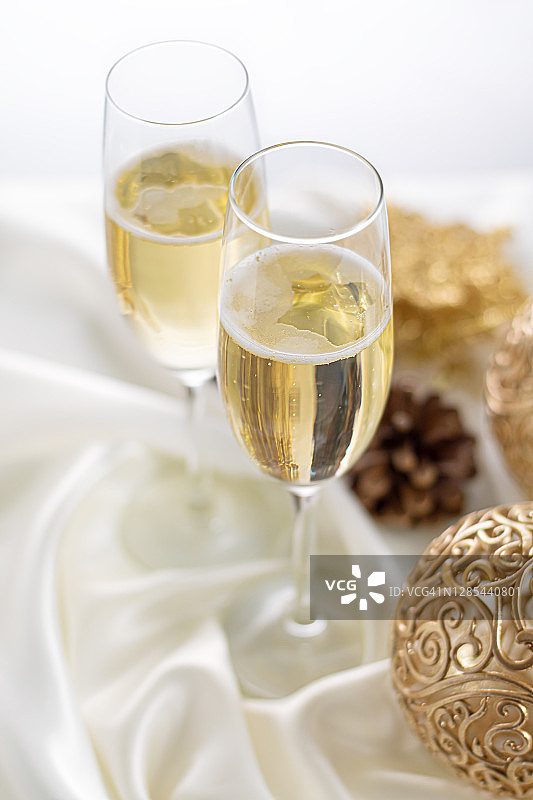 用香槟庆祝圣诞节和新年。两个用白色布料装饰的香槟杯。图片素材