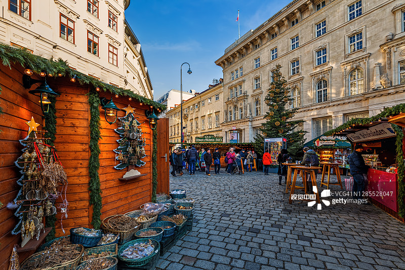 奥地利维也纳，鹅卵石街道上的木制小摊出售圣诞纪念品。图片素材