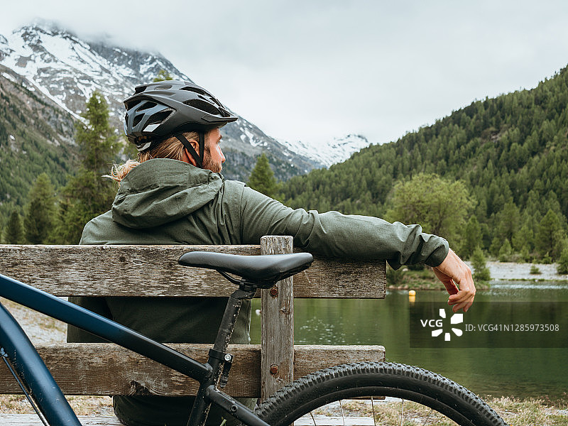山地自行车手在湖边休息图片素材