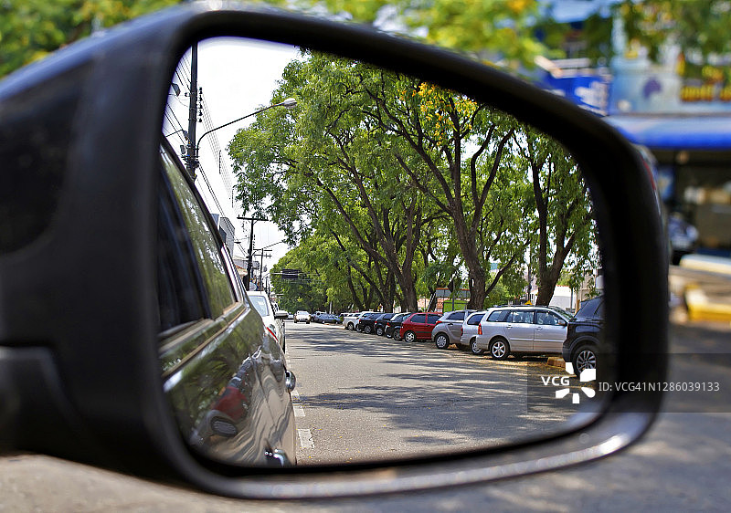 许多汽车停在后视镜在巴西的一个小城市。图片素材
