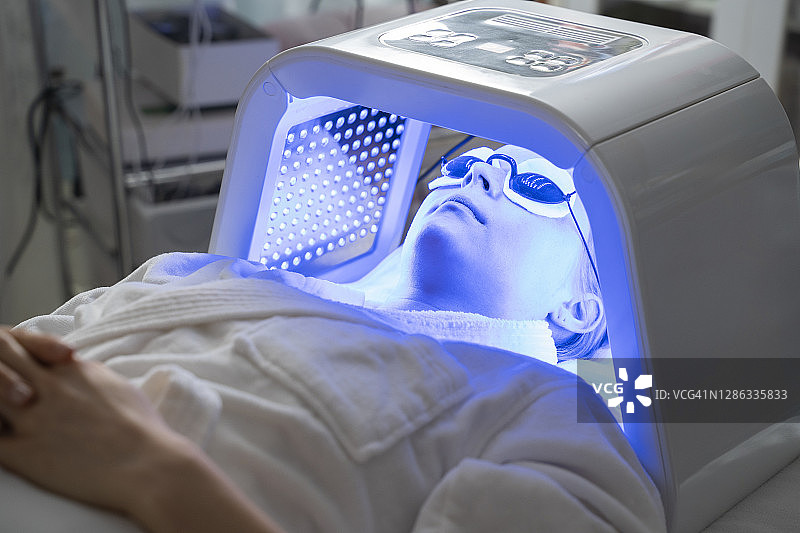 一位年轻女性的LED面膜再生治疗。图片素材