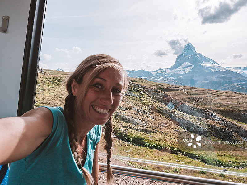 快乐的女人在瑞士策马特的火车上自拍图片素材