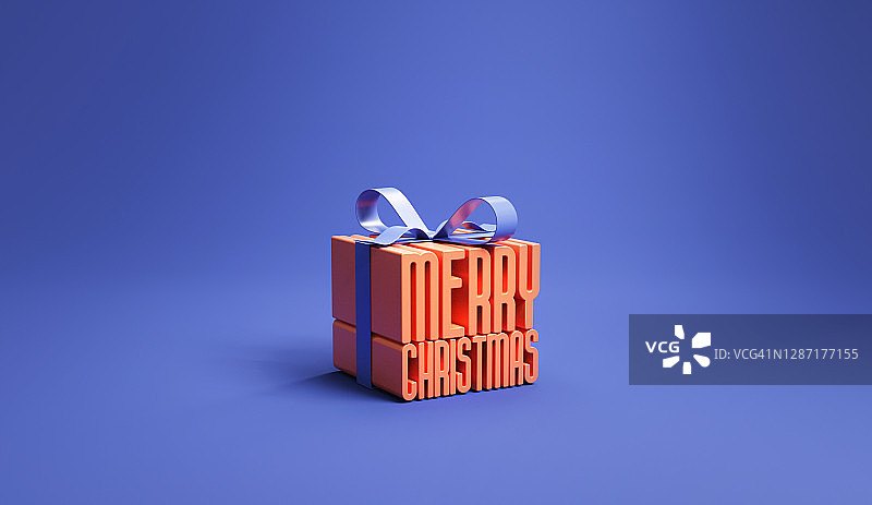 圣诞快乐在礼盒包装与蓝色背景丝带，想法和创意，复制空间。图片素材