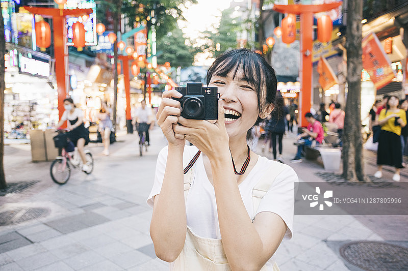 台湾女子用复古相机拍照图片素材