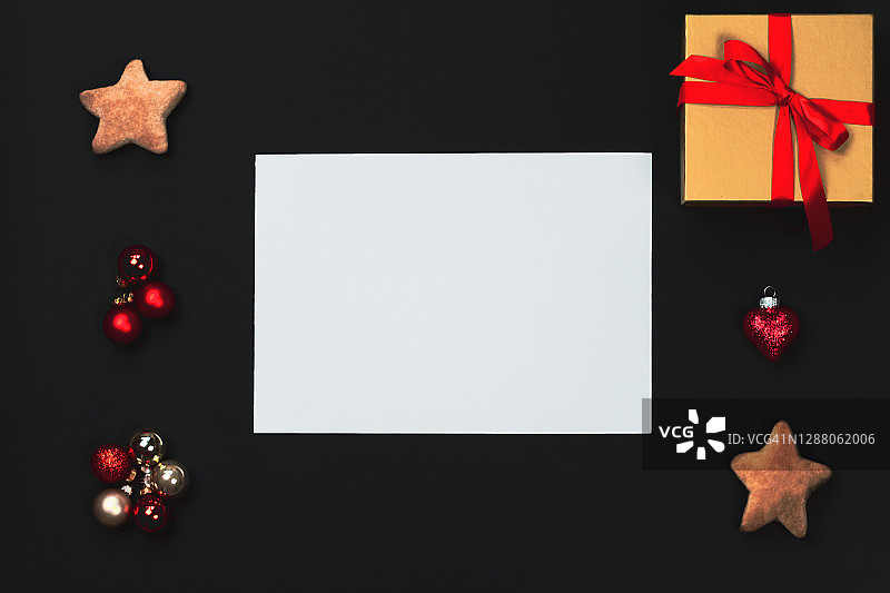 圣诞主题的平铺，空白纸在中间，黑色的背景。图片素材