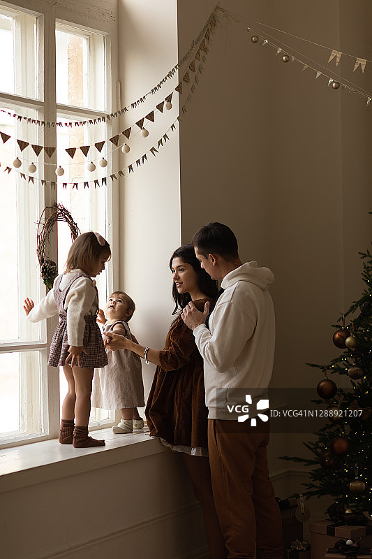 漂亮的白人两个小女孩和他的父母在圣诞之家。图片素材
