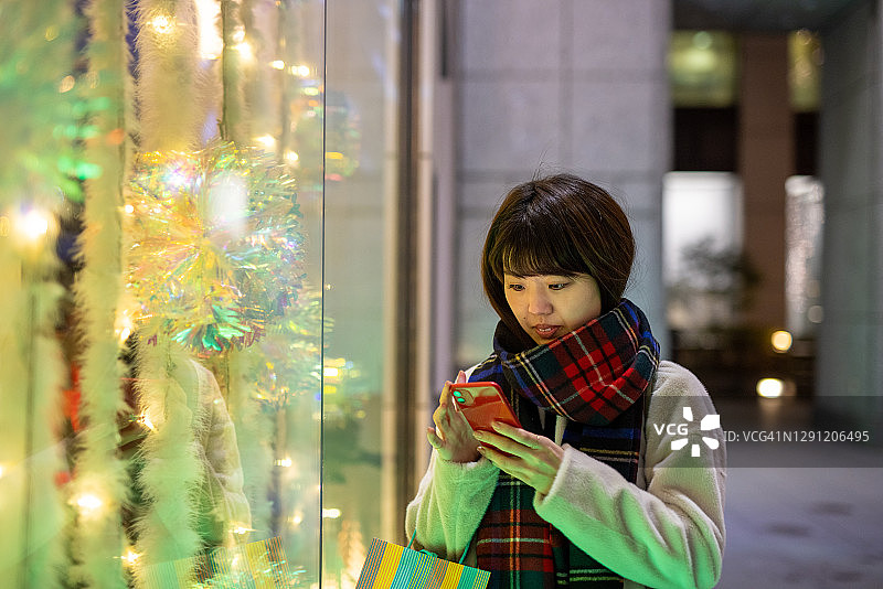 一个年轻女子在圣诞之夜等她的朋友图片素材