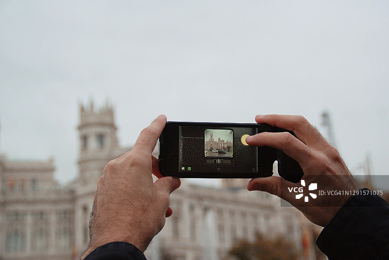 西班牙马德里，男孩用手机拍照图片素材