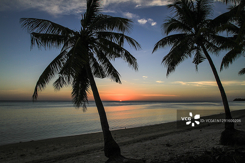 日落的热带海滩与椰子树图片素材