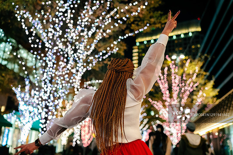 年轻女子晚上在街上快乐地跳舞图片素材