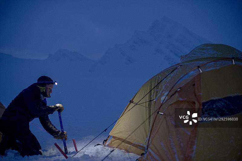 黄昏时探险者在准备冬季露营地图片素材