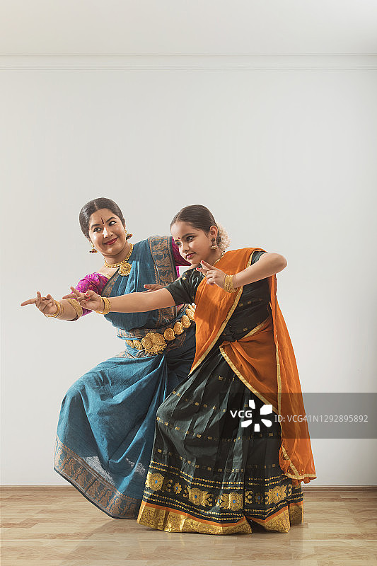 年轻的bharatnatyam舞者向她的老师学习。图片素材