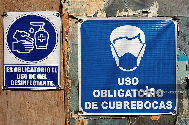 建筑工地护栏上的西班牙语covid-19健康和安全标识图片素材