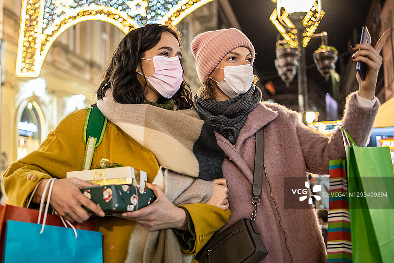 两个戴口罩的女性朋友在疫情期间购物图片素材