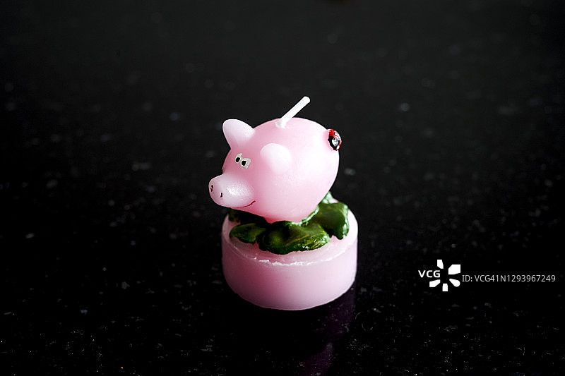 粉红猪蜡烛与黑色背景图片素材