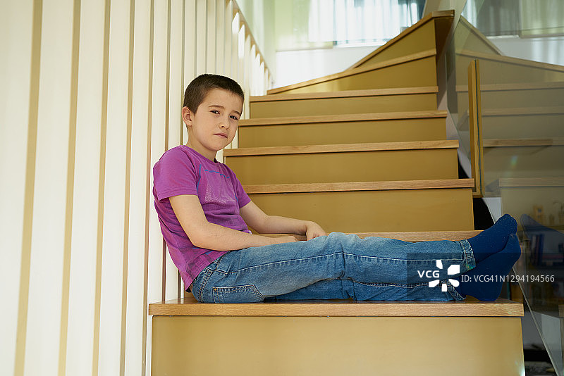 小孩子坐在你家楼梯上看着摄像机图片素材