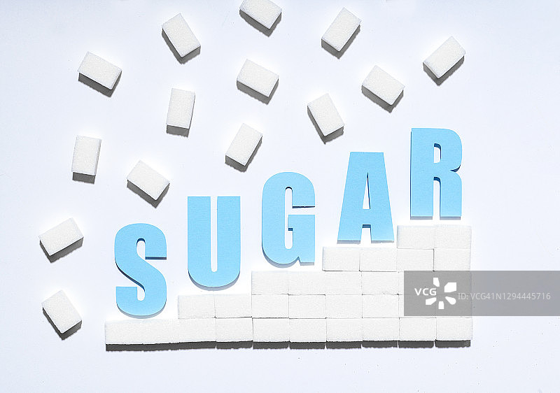 蓝色的糖字母文字与纸上的白糖方糖图片素材