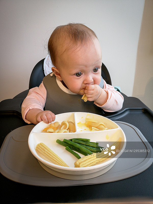 在挪威的奥斯陆，一个饥饿的婴儿正在享受她的食物图片素材