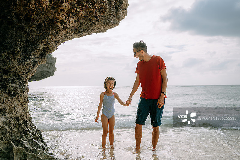 快乐的父亲和小女儿在海滩上图片素材
