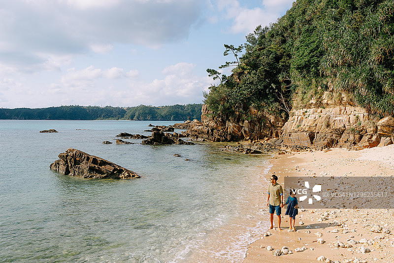 父亲和小女儿在日本海滩上散步图片素材