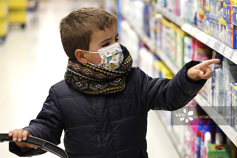 小男孩戴着口罩在超市购物图片素材