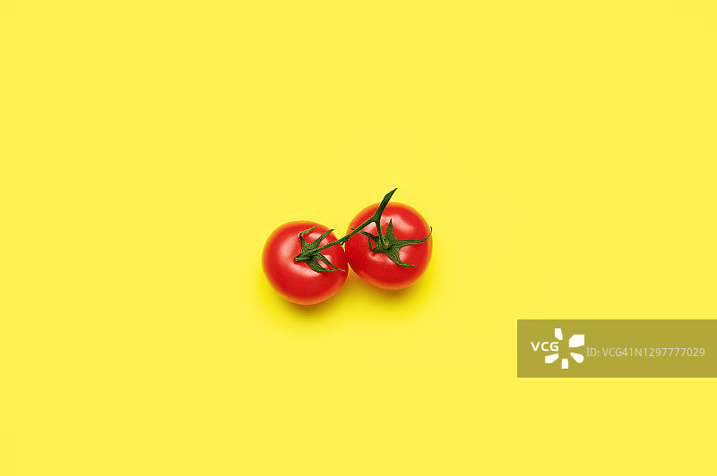 鲜红熟透的番茄平铺在黄色的背景上图片素材