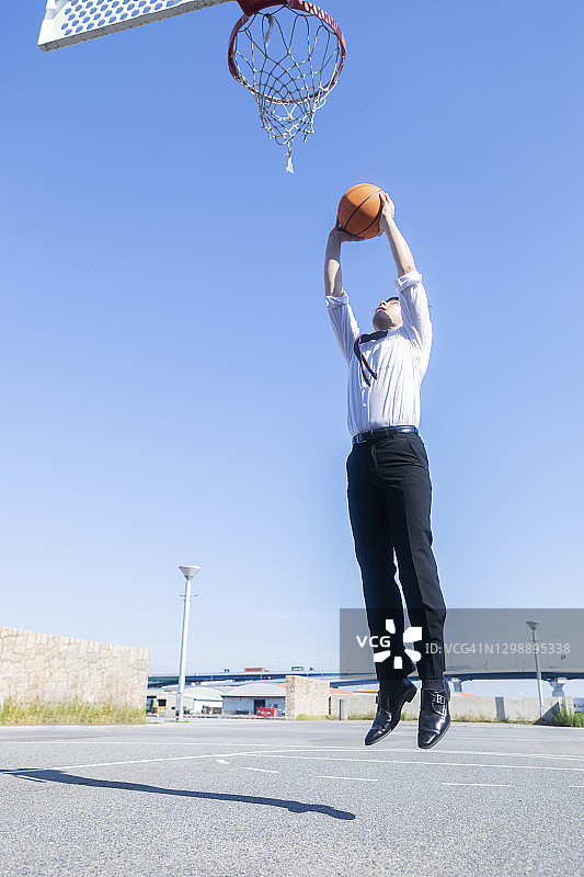 一个男人在公园里打篮球图片素材