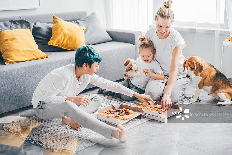 家人聚在一起，在家吃披萨。图片素材