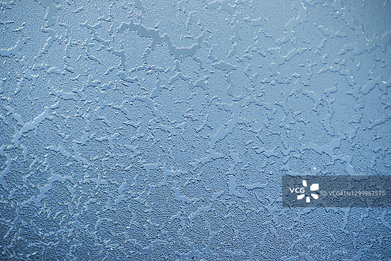 蓝色背景的玻璃上结霜图片素材