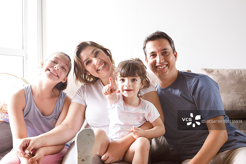 沙发上一个幸福微笑的家庭的肖像图片素材