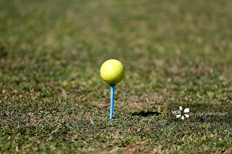 黄色高尔夫球，蓝色球座。图片素材