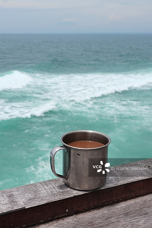 对着海洋的一杯咖啡的特写图片素材