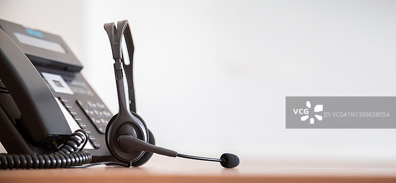 沟通支持，呼叫中心和客户服务帮助台。电话键盘上的VOIP耳机。图片素材
