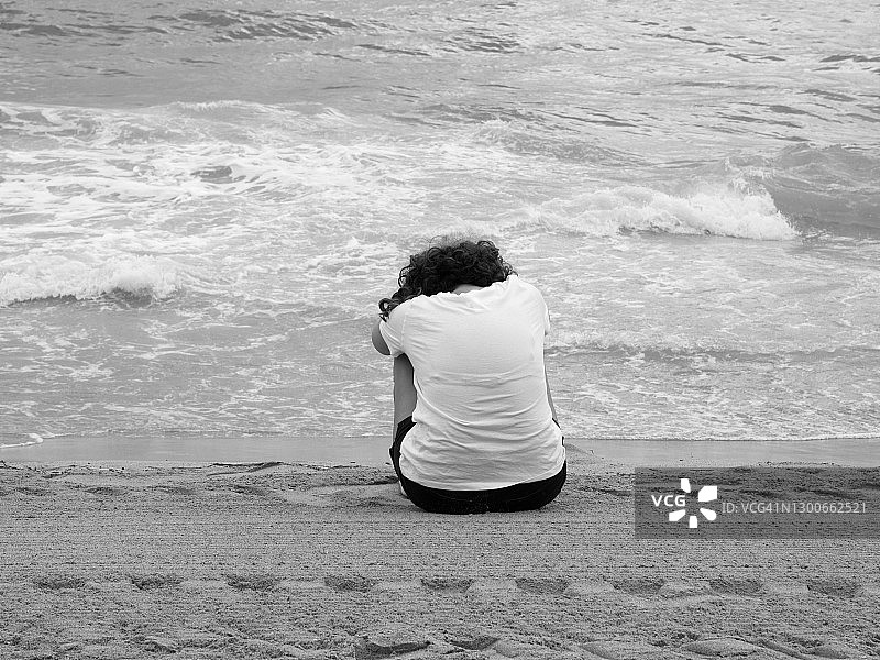 在海滩上悲情的黑白女人图片素材