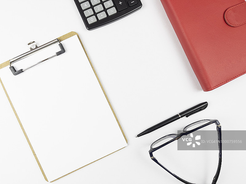 空白记事本，红色日记本，钢笔，眼镜和计算器。商业，金融，经济和行动计划的概念和背景。白色背景。图片素材
