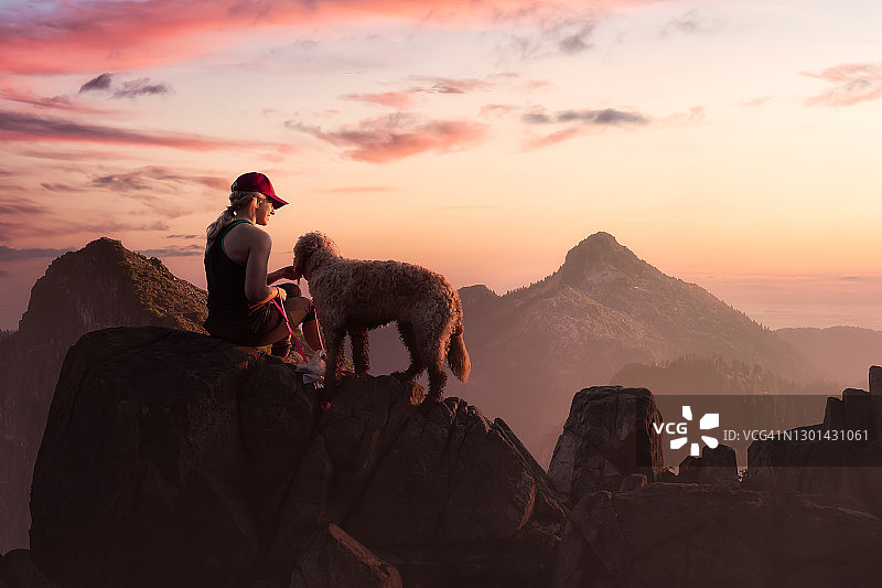爱冒险的女孩和一只狗在落基山顶徒步旅行图片素材