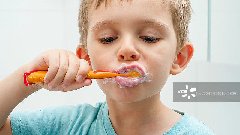有趣的蹒跚学步的小男孩在早上清洁和刷牙的肖像。牙齿卫生和儿童保健的概念图片素材