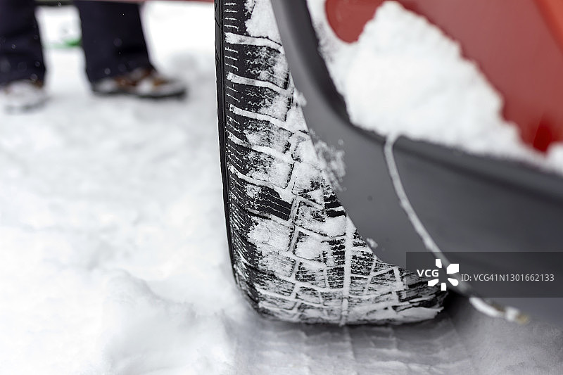 汽车轮胎在被雪覆盖的冬季道路上的照片。图片素材