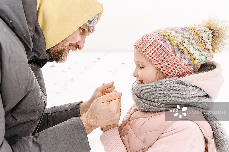 父亲在冬天牵着女儿冰冷的手的特写图片素材